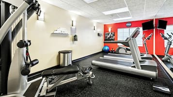 A gym with treadmills, weight machines, and exercise balls.