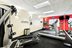 A gym with treadmills, weight machines, and exercise balls.