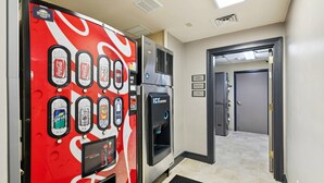 Una máquina expendedora con diversas opciones de bebidas, un dispensador de agua y un refrigerador.