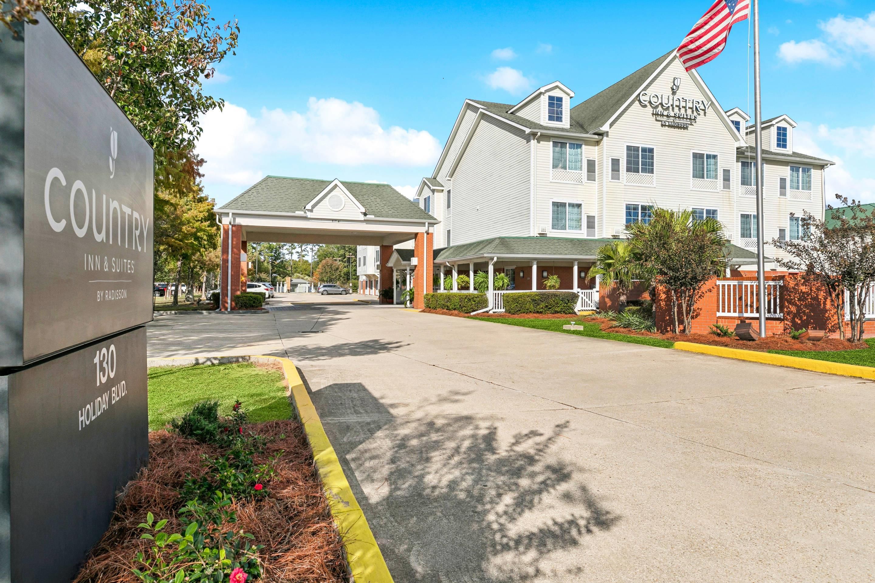 Un établissement Country Inn & Suites by Radisson doté d’une entrée couverte et d’un drapeau.
