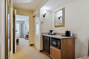 A hotel room with a kitchenette, a microwave, a coffee maker, and a mirror. - Country Inn & Suites by Radisson, Covington, LA (Covington)