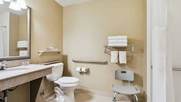 A bathroom with a sink, toilet, mirror, towel rack, and shower curtain.