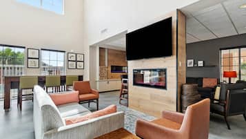 A spacious living area with a fireplace, comfortable seating, and a large TV screen.