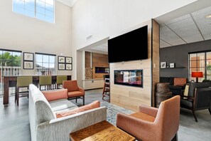 A spacious living area with a fireplace, comfortable seating, and a large TV screen.