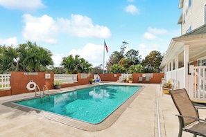 A swimming pool with a no diving sign, lounge chairs, and a flagpole with an American flag. - Country Inn & Suites by Radisson, Covington, LA (Covington)