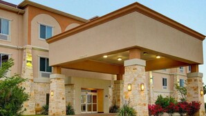 A hotel entrance with a covered walkway, stone pillars, and a clear sky. - Comfort Inn & Suites Alvarado (Alvarado)