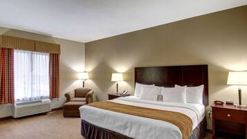 A hotel room with a large bed, two bedside tables with lamps, a chair, and a window with curtains.