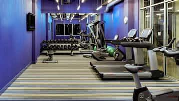 A gym with treadmills, dumbbells, and exercise equipment.