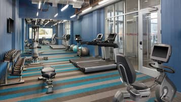 A gym with treadmills, elliptical machines, and free weights.