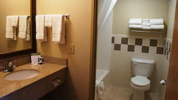 A bathroom with a sink, mirror, and a toilet.