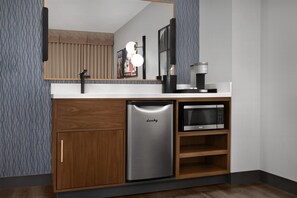 A compact kitchen with a built-in refrigerator, microwave, and coffee maker. - Embassy Suites by Hilton Birmingham Hoover (Birmingham)