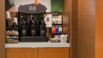 Una estación de café con dispensadores de la marca, un tablero de menú y diversos artículos relacionados con el café.