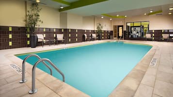 Una piscina techada, sillones reclinables de piscina