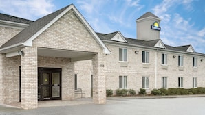 A Days Inn with a brick facade, a covered entrance, and a small tower with the hotel’s logo. - Days Inn by Wyndham Greensboro NC (Greensboro)