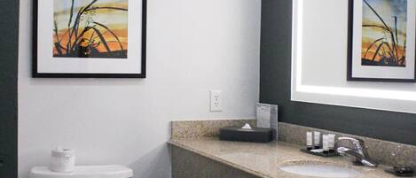 A modern bathroom with a toilet, sink, and towel rack.