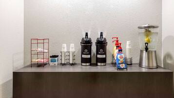 A coffee station with a coffee machine, milk frother, and a water dispenser.