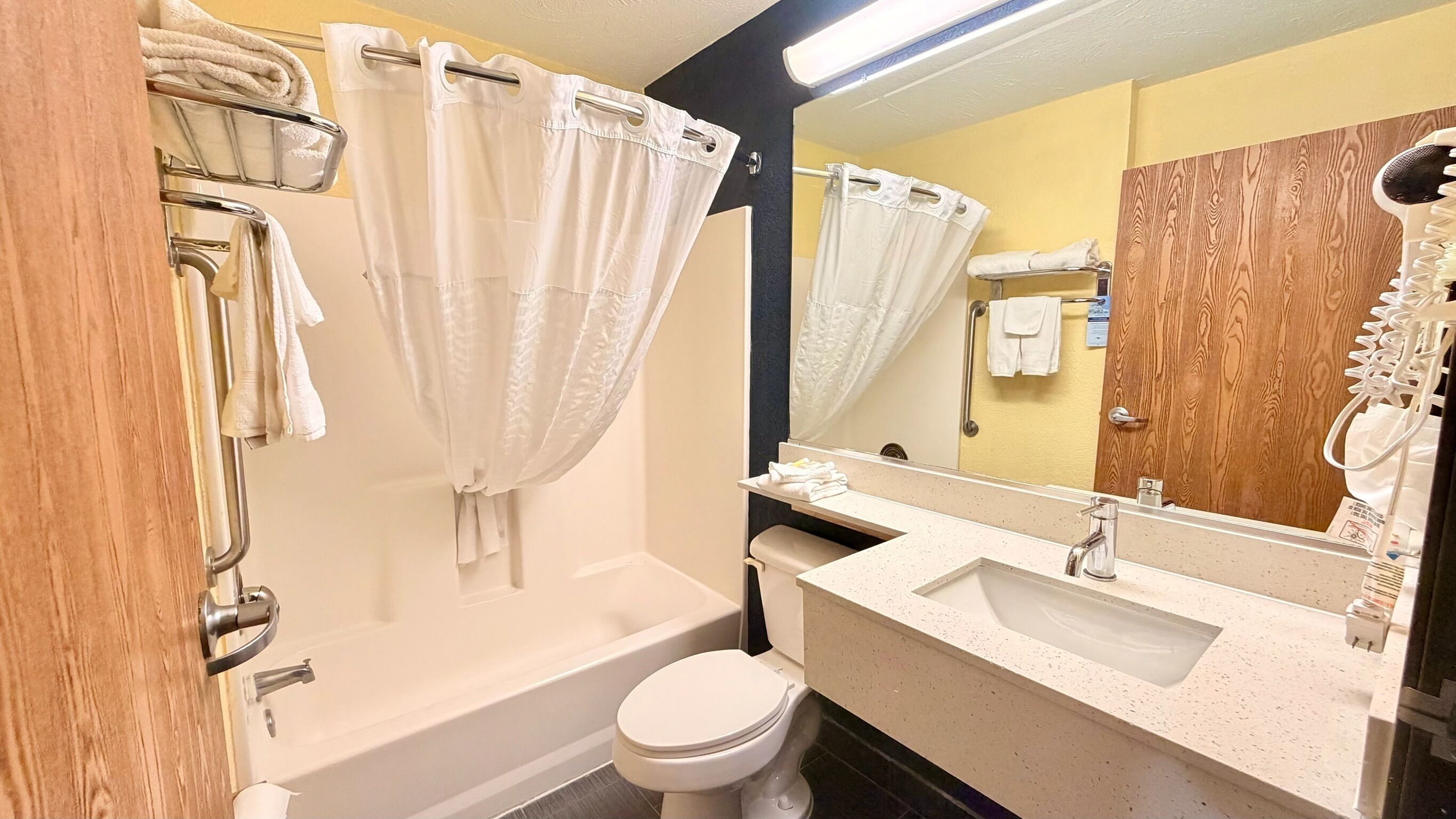 Un baño con bañera, inodoro, lavabo y espejo.