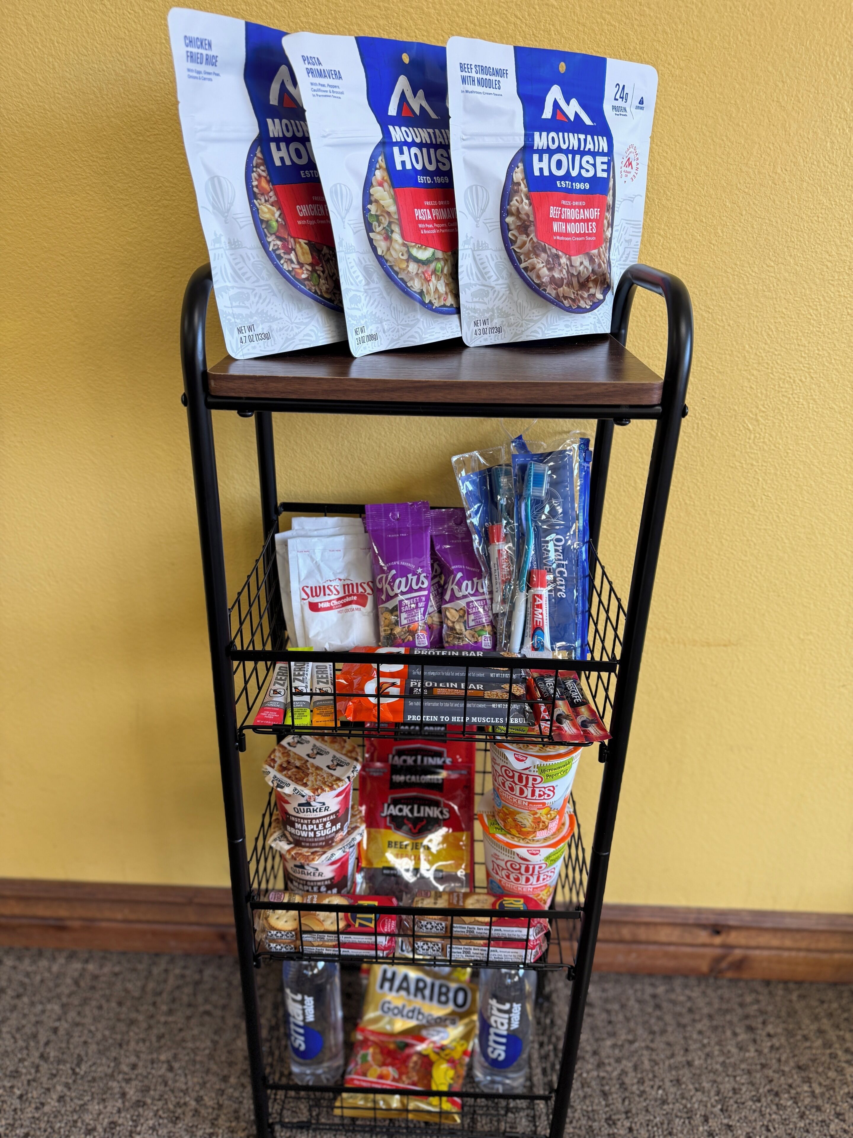 A metal cart with frozen food items and snacks.