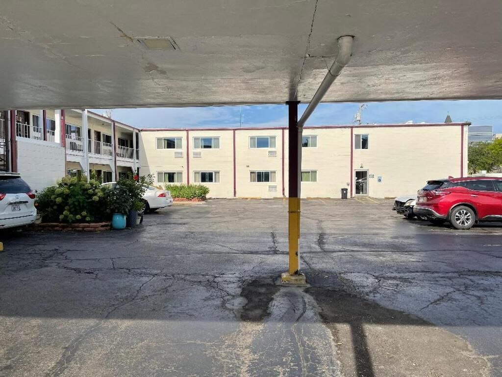 Un espace de stationnement avec un bâtiment en arrière-plan.