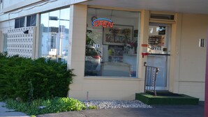 A storefront with a large window, a sign that says "OPEN", and a door labeled "OFFICE".