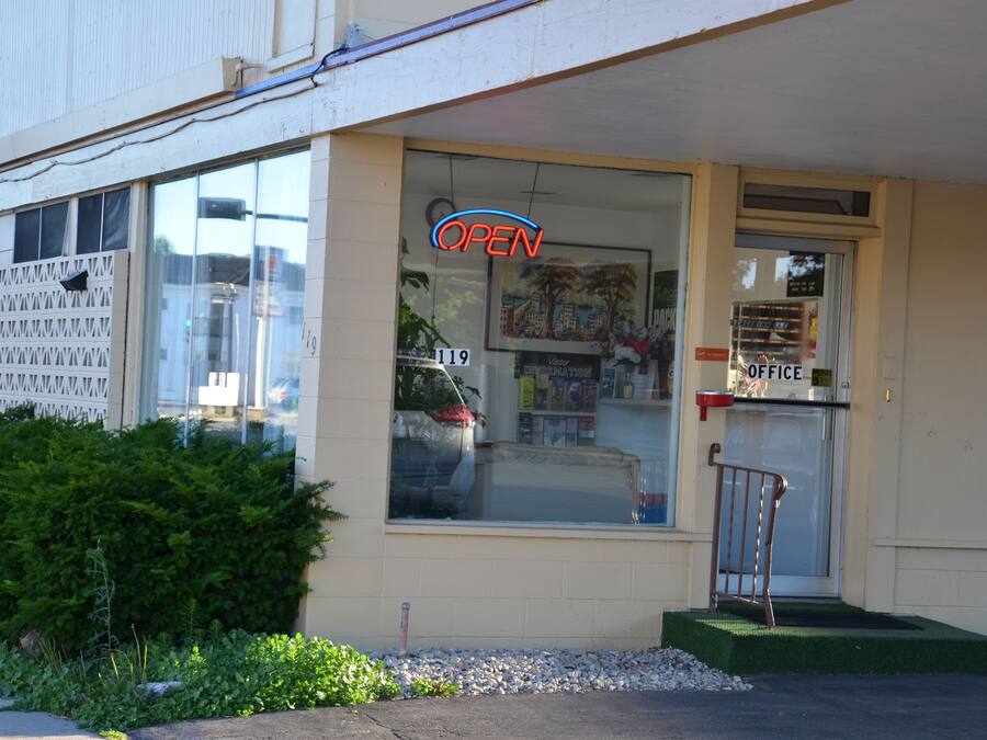 A storefront with a large window, a sign that says "OPEN", and a door labeled "OFFICE".