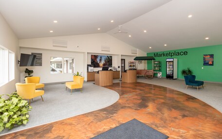 A spacious lobby with a curved floor, a reception desk, and a green wall labeled 'Marketplace'.