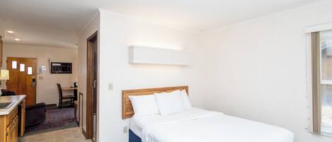 A hotel room with a bed, a desk, and a chair.
