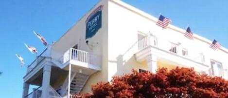 A white building with multiple American flags and a sign that reads "Hotel".