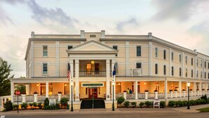 A large, historic hotel with a grand entrance, multiple balconies, and a well-lit facade. - Hotel Perry (Petoskey)