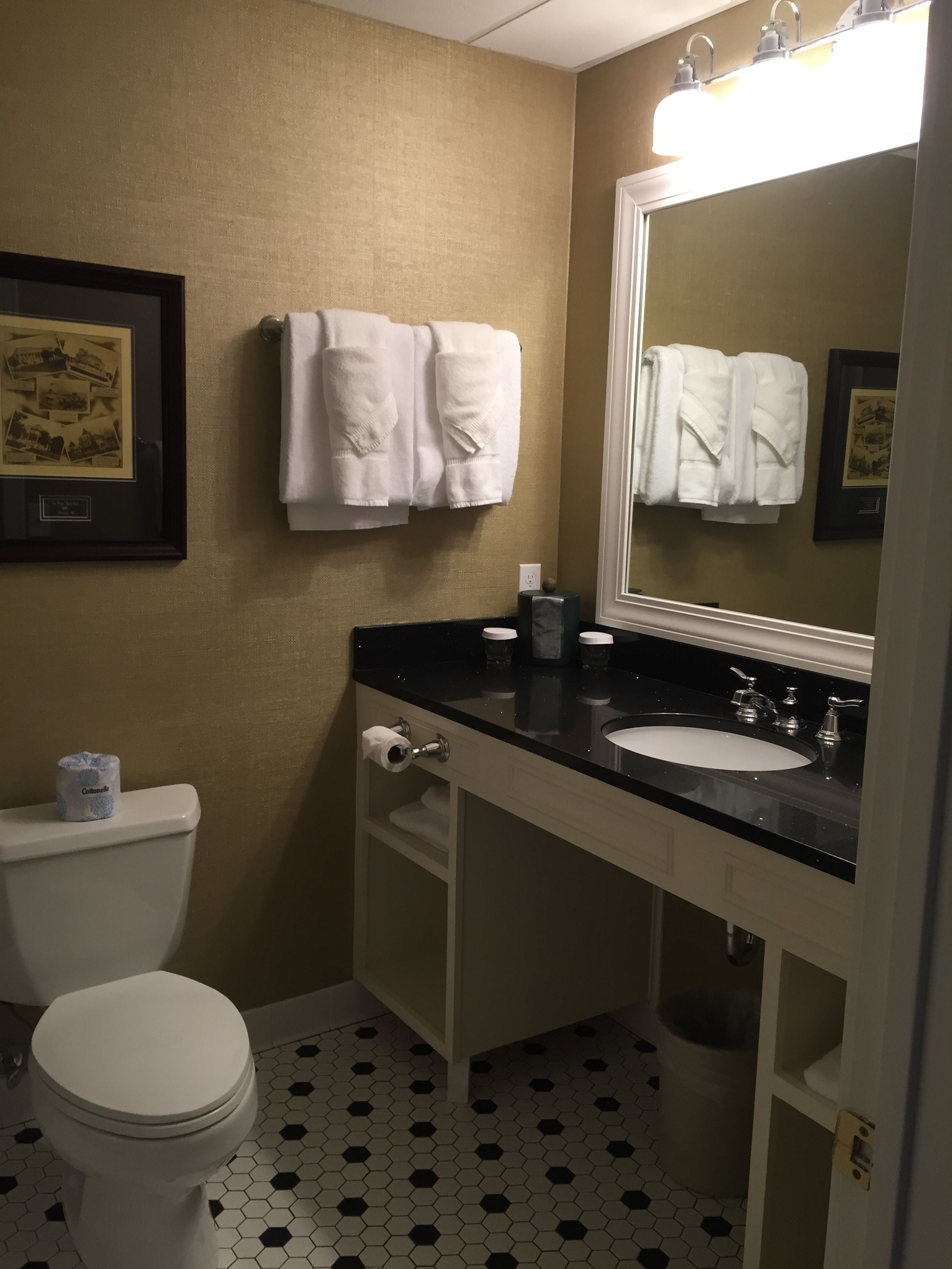 A bathroom with a toilet, sink, and towel rack.