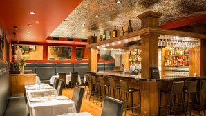 A restaurant with a bar area, booths, and a bar counter with stools. - White Buffalo Club (Jackson)