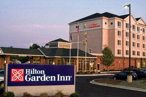 A Hilton Garden Inn hotel with a prominent sign, multiple flags, and a parking lot with cars. - Hilton Garden Inn Aberdeen (Aberdeen)
