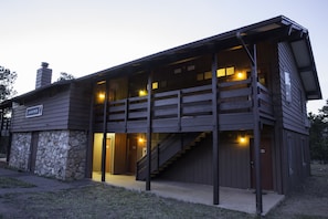 A two-story wooden building with a stone foundation, a visible staircase, and a sign reading "JUNIPER".