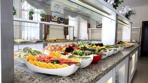 A buffet with various food items and a glass display case.