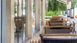 An outdoor seating area with wicker furniture and checkered tablecloths.
