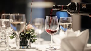 A bottle of red wine being poured into a glass. - Loenfjord (Stryn)