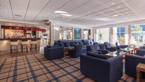 A modern hotel lobby with a bar area, seating arrangements, and large windows offering views. - Loenfjord (Stryn)