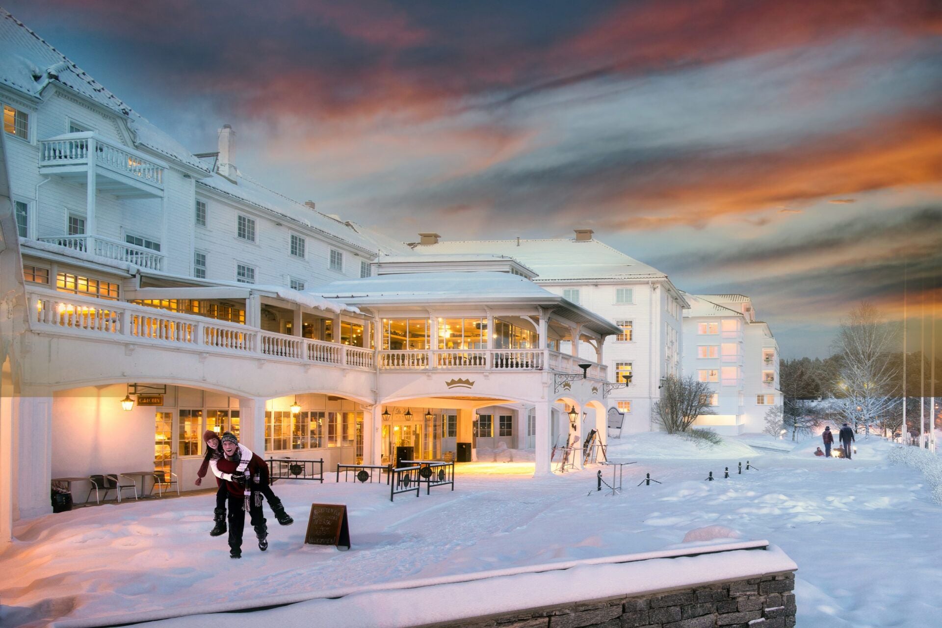 Un hotel grande de varios pisos con un espacio al aire libre cubierto y nieve en el suelo.