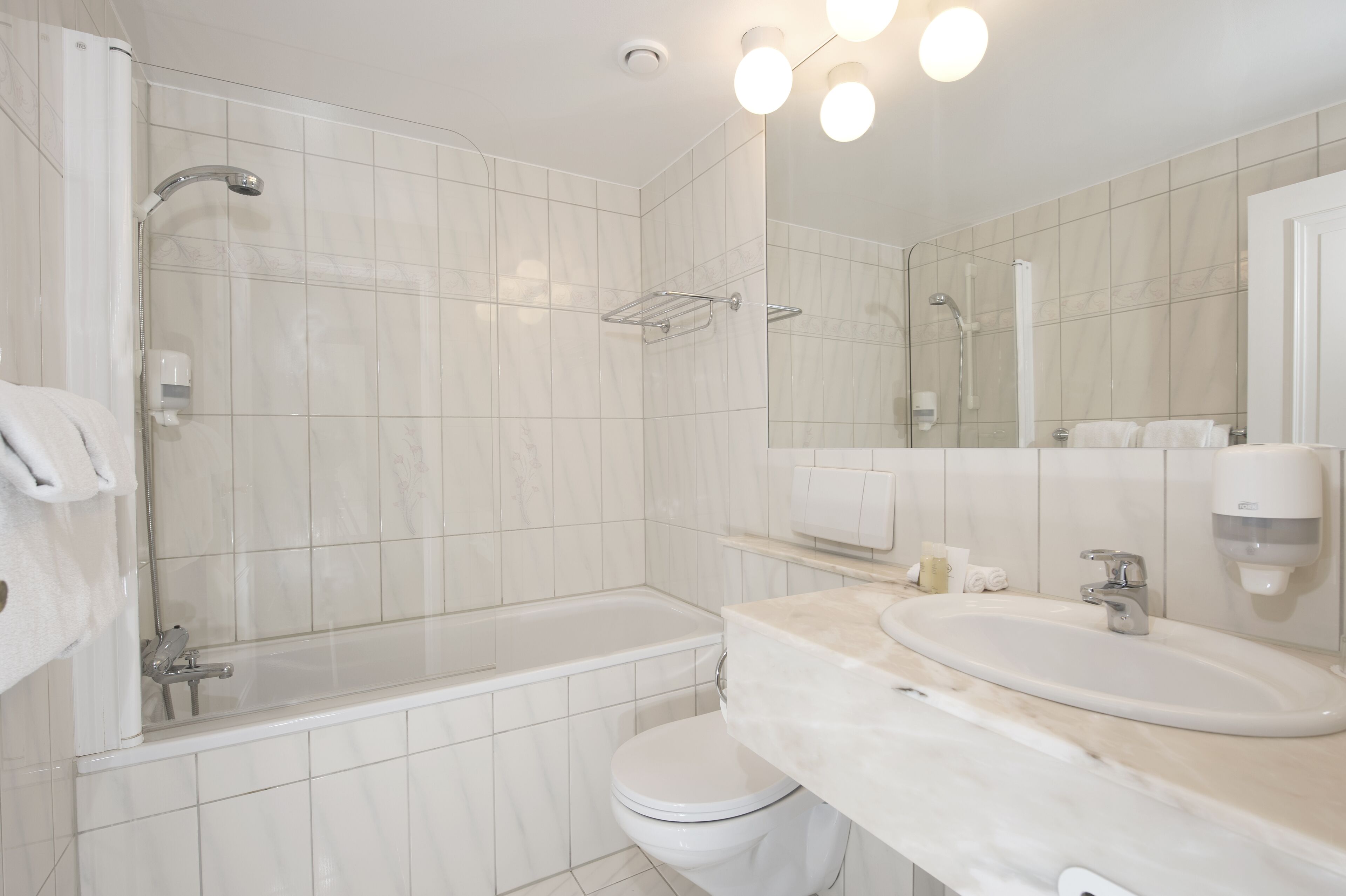 A modern bathroom with a bathtub, toilet, and sink.