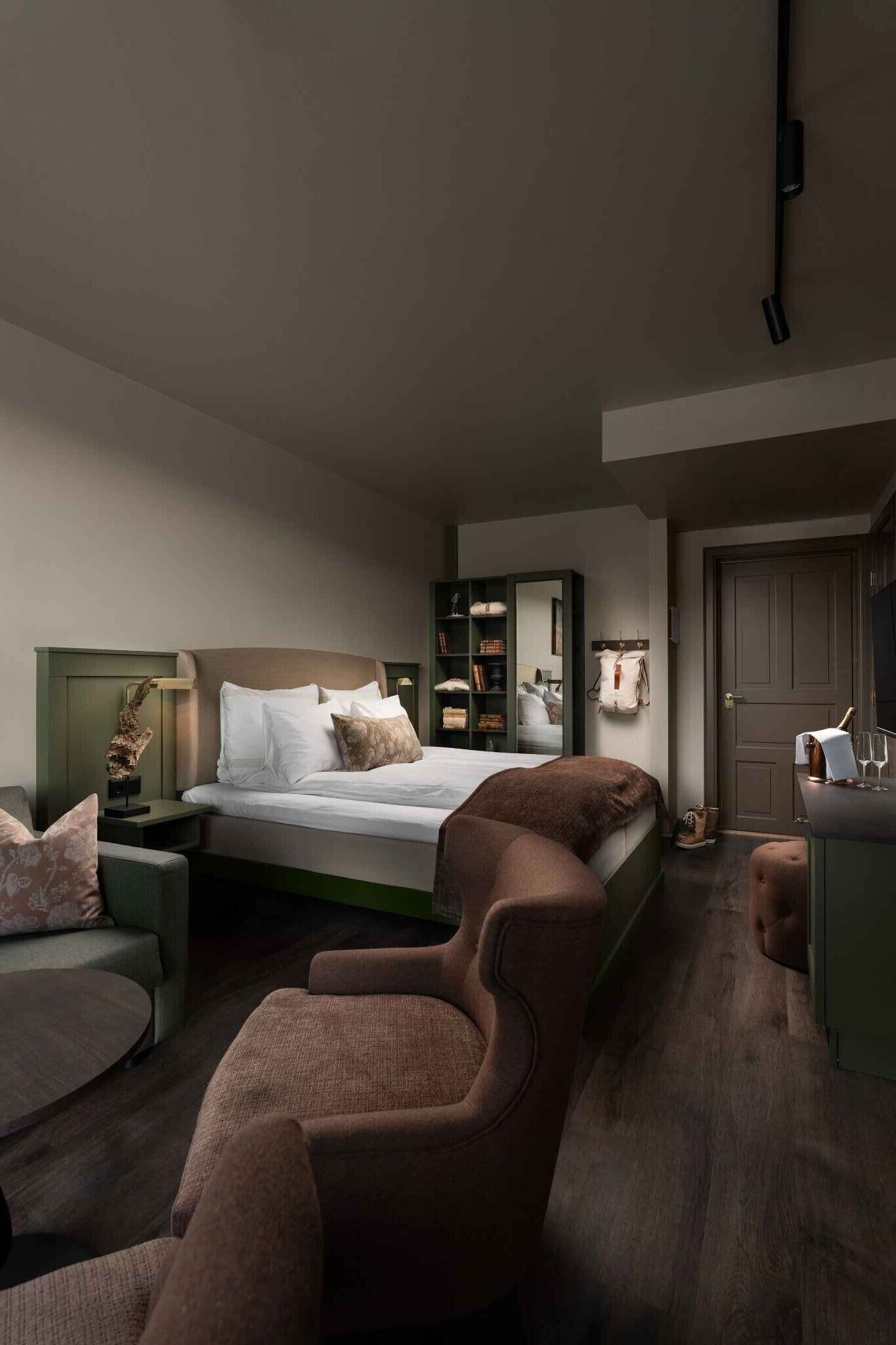 A bedroom with a bed, nightstands, a sofa, and a chair.