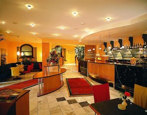 A hotel lobby with a bar area, seating, and a reception desk. - Rokohof (Klagenfurt am Woerthersee)