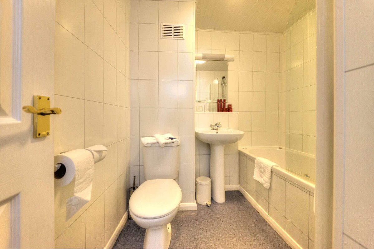 Un baño pequeño con inodoro, lavabo y bañera.
