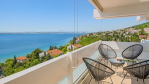 Een balkon met uitzicht op zee en een stad.