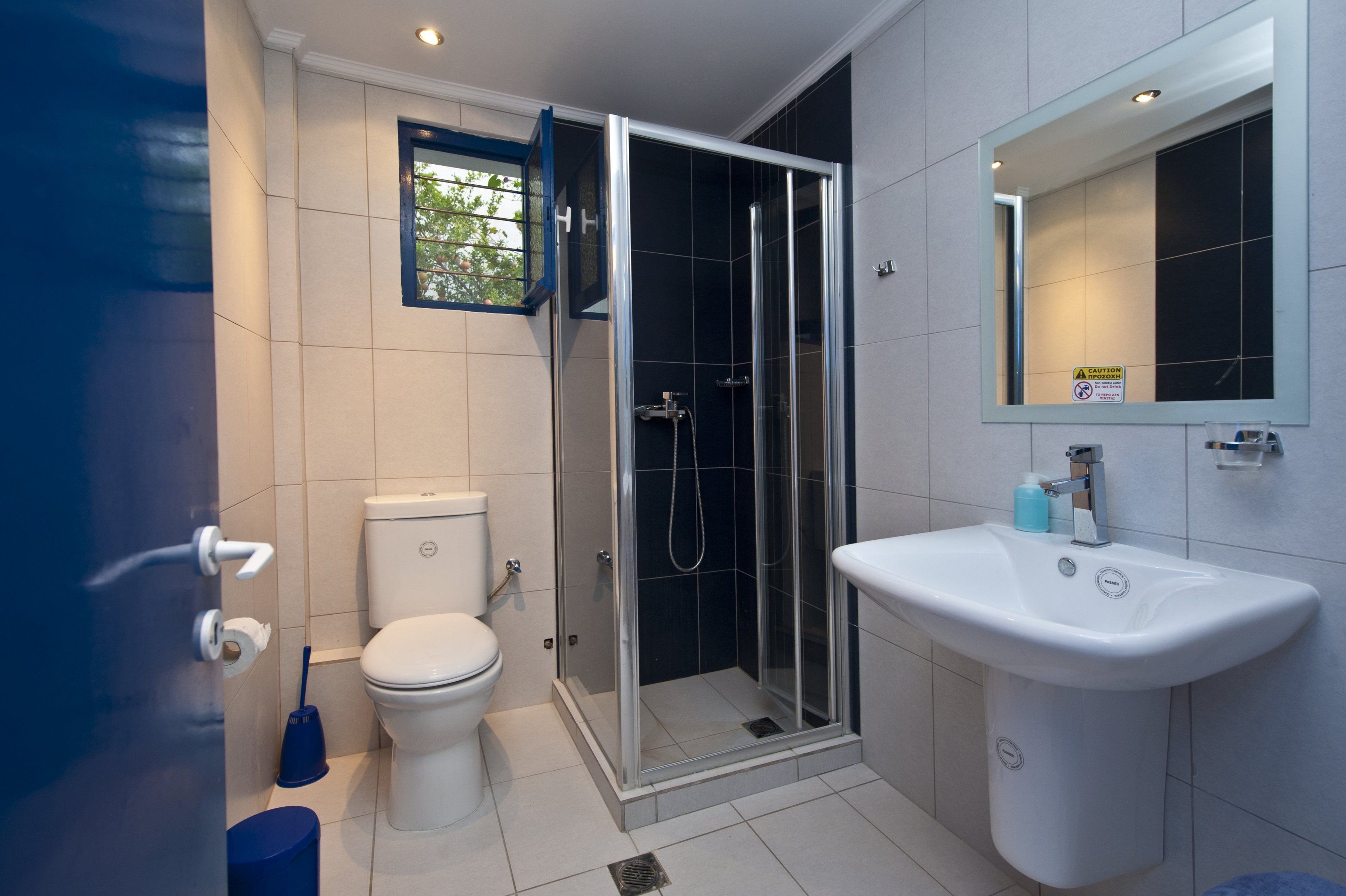 A modern bathroom with a toilet, shower, and sink.