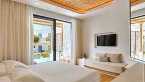Una camera da letto moderna con un letto grande, una televisione, un divano e un balcone con vista.