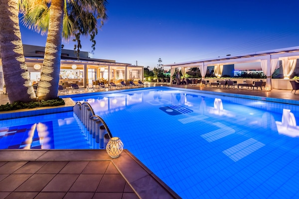 Een buitenzwembad, parasols voor strand/zwembad