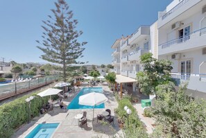 Um hotel com piscina, área de estar externa e vista da região ao redor.