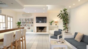 Una sala de estar moderna con chimenea, zona de estar y una estantería.