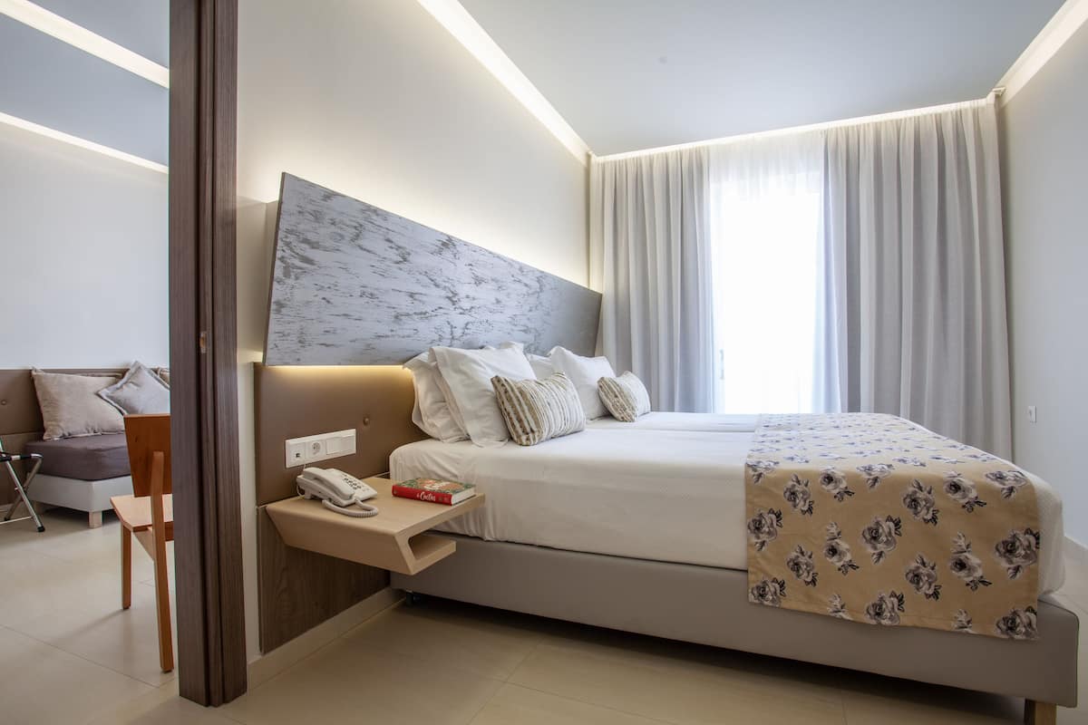 A modern bedroom with a large bed, bedside table, and a headboard with a marble-like design.