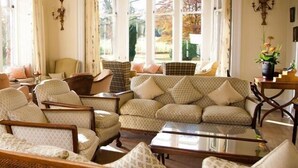 A cozy living room with a sofa set, armchairs, and a coffee table. - Ballathie Sportsmans Lodge (Perth)
